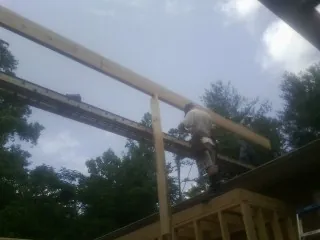 Carpenter setting a ridge beam over a new addition frame — Ice Dam Removal by Roofing Brothers in Gouldsboro