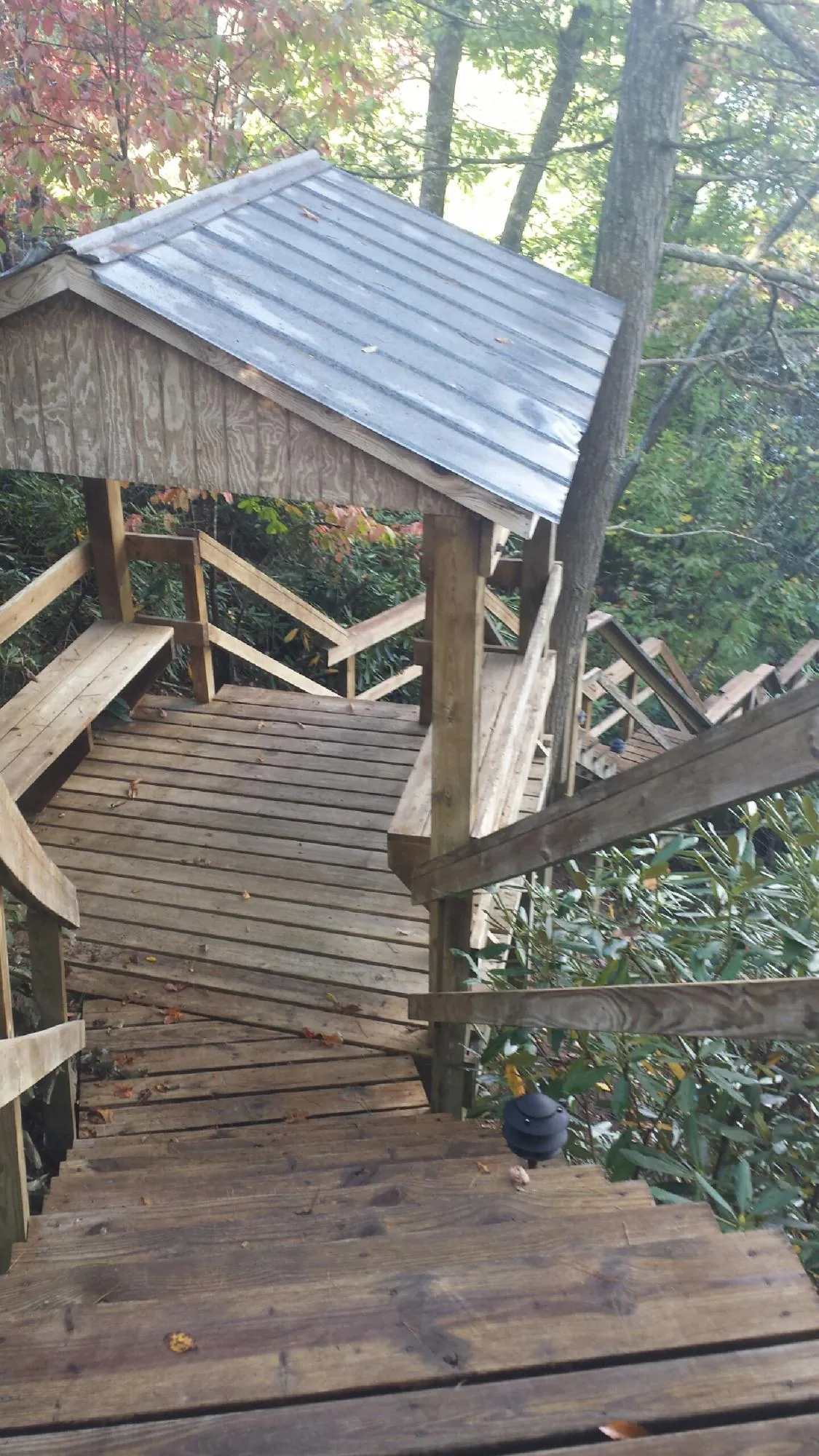 Metal roofed shelter over wooden steps on a wooded walkway — Skylight Repair & Installation work by our crew in Gouldsboro