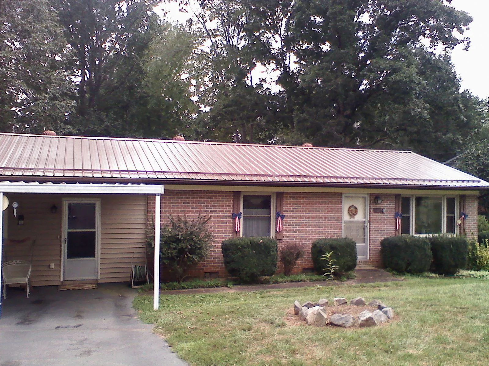 Bronze metal roof and carport on a brick ranch home — Roof Repair work by our crew in Gouldsboro